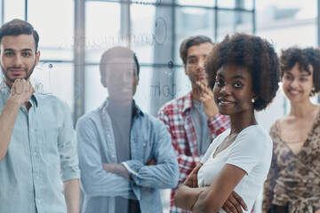 Fototapeta premium a team of young designers sticking notes on glass in a modern office