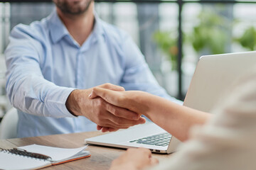 Young business people shaking hands in the office. Finishing successful meeting.