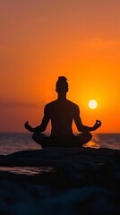 Man in yoga pose, zen meditation at sunset 