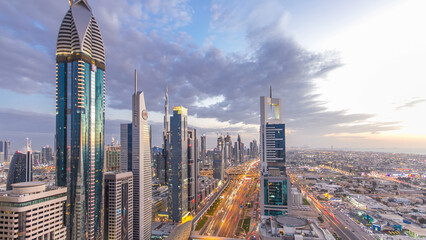 Dubai downtown architecture day to night timelapse. Top view over Sheikh Zayed road with illuminated skyscrapers and traffic.