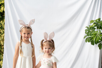 Two cute little girls wearing sparkly bunny ears and holding hands. Sisterhood. 
