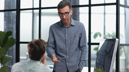 Two colleagues in casual office or home office doing paperwork working together teaching