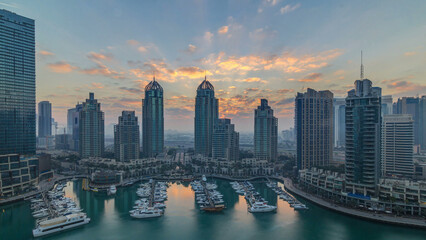 Fototapeta na wymiar View of modern skyscrapers shining in sunrise lights timelapse in Dubai Marina in Dubai, UAE.