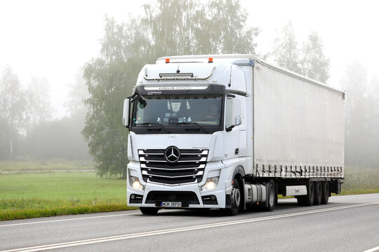 White Mercedes-Benz Actros 1848 Truck Semi Trailer Trucking on a Foggy Summer Morning.