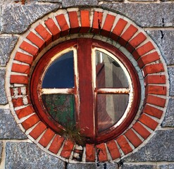 A round window on the stone wall of a building