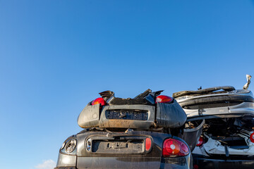 Stacked cars at a junkyard in the South-Holland village of Lisse in the Netherlands. On a blue sky.