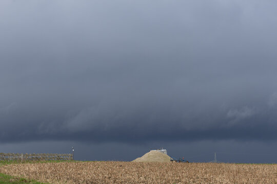 Kalk Haufen f&uuml;r den Acker unter gro&szlig;en Wolken an einem Tag mit Regen und Sturm 