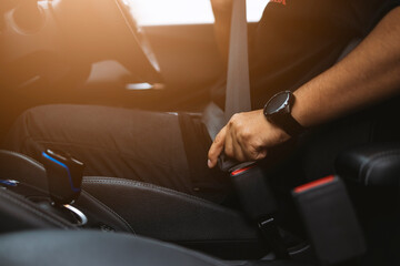 Close-up hand man driver fastens seat belt. - obrazy, fototapety, plakaty