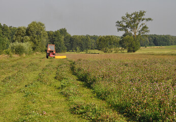 Traktor koszący trawę na polu, sianokosy