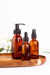 Face moisturizer cream, serum, essential oil in amber glass bottle and isolated on white background. Flat lay, top view. Set for skin and body care beauty products..