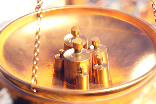 Vintage Brass Weights on Reflective Golden Balance Scale - Precision Symbolized