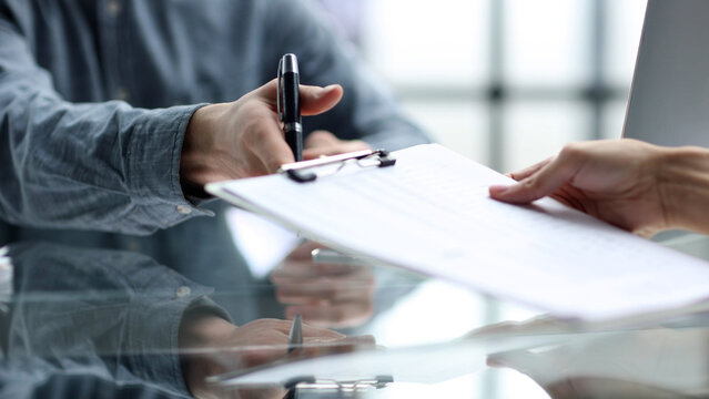 Close-up discussion of documents at the desk in the office