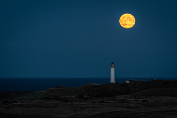lighthouse on the beach with full moon