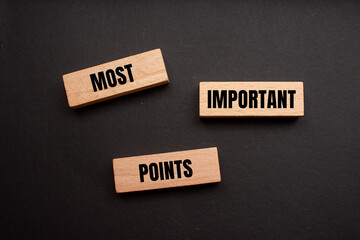 Most important points words written on wooden blocks with black background. Conceptual symbol. Copy space.
