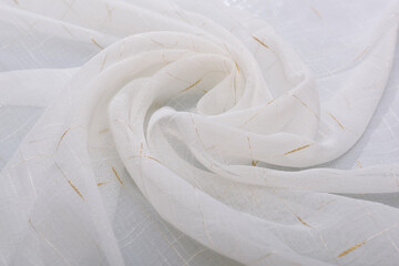 The fabric is white, rolled up by the inversion of the waves. Folds of the curtain in the form of a...