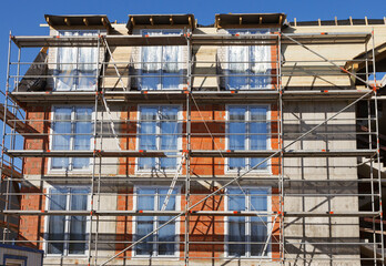 The facade of a house under construction with scaffolding