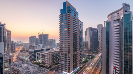 Aerial view of Dubai Marina after sunset from a vantage point day to night timelapse.