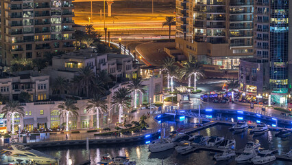 Luxury Dubai Marina canal with passing boats and promenade night timelapse, Dubai, United Arab Emirates