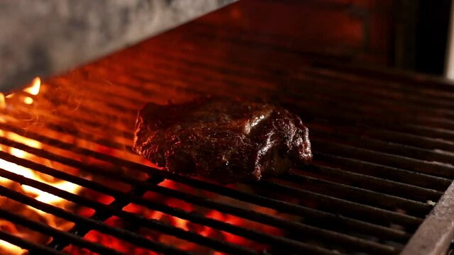 Chef cooks steak on the grill