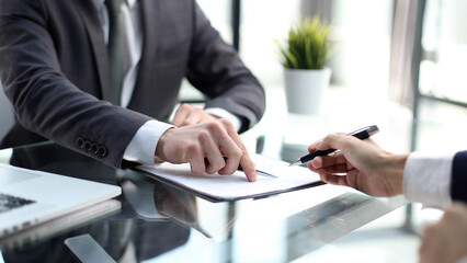 Businessmen in the office are discussing documents in close-up