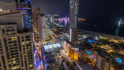 Aerial view of modern skyscrapers and beach at Jumeirah Beach Residence JBR night timelapse in Dubai, UAE