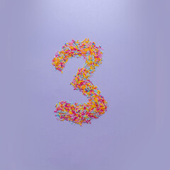 Number three made of sugar sprinkles on a purple background. Creative alphabet concept.