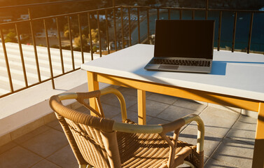Laptop on the table on the balcony. Freelancing and remote work concept. - 767149750
