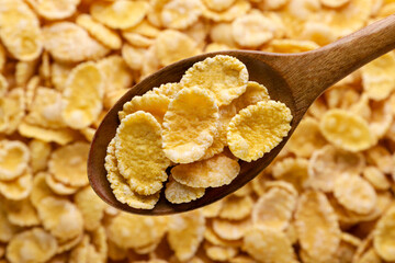 Corn flakes in a wooden spoon background. Top view. - 767153175