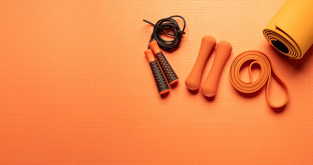 orange background with fitness equipment with free space for text