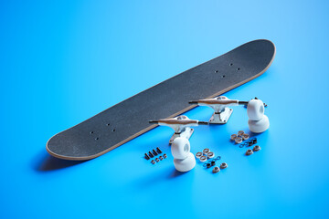 Disassembled Black Skateboard and Components on Bright Blue Surface - 767159794