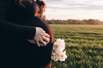 Pregnant Woman Holding a Flower in a Field