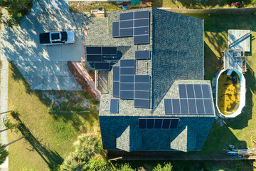 Aerial view of typical american building roof with rows of blue solar photovoltaic panels for producing clean ecological electric energy. Renewable electricity with zero emission concept - obrazy, fototapety, plakaty