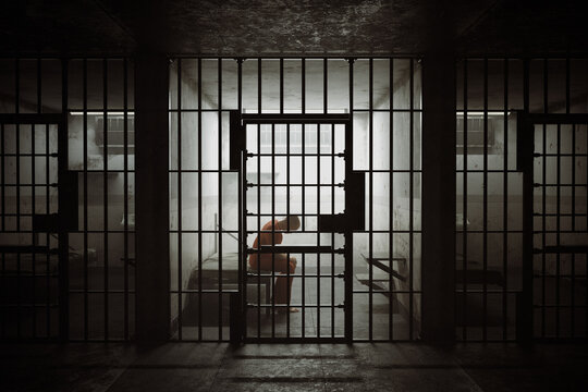 Evocative Silhouette of a Lone Person Inside a Dark, Desolate Jail Cell