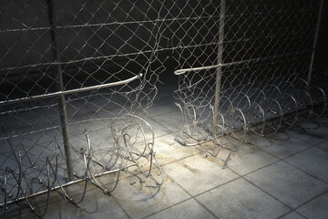 Vandalized Security Fence with Sharp Razor Wire in a Neglected Urban Area