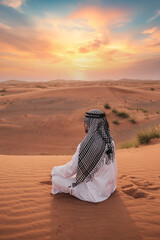 Young man praying in desert during ramadan month