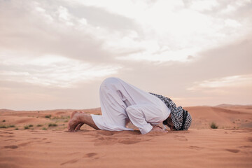Fototapeta na wymiar Young man praying in desert during ramadan month