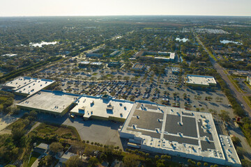 Many parked cars on store parking lot with lines and markings for parking places and directions. Place for vehicles in front of a shopping mall center - obrazy, fototapety, plakaty