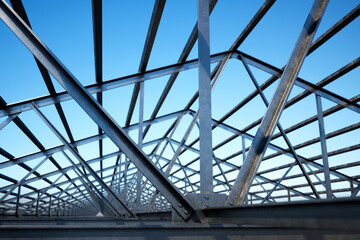 Innovative Geometric Steel Framework Captured Against a Vibrant Blue Sky - obrazy, fototapety, plakaty