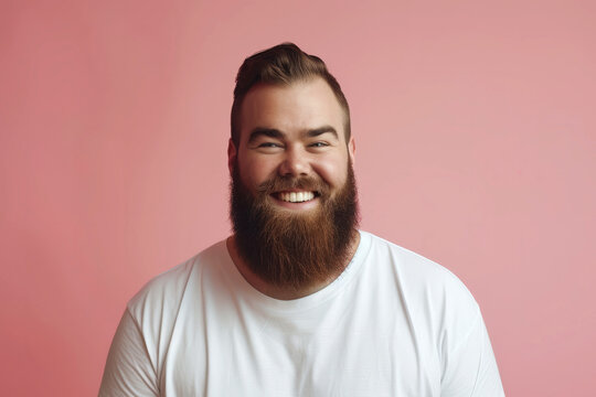 Portrait of happy bearded man in white t-shirt smiling straight at camera isolated on blank pink background with space for text or inscriptions
