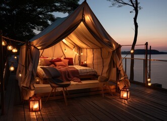 Cozy glamping setup on wooden deck overlooking seascape at dusk