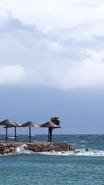 Powerful waves crashing the coast of Njivice, Croatia one day after Storm Ciar&aacute;n smashed into Krk Island. Beautiful disquiet blue sea surface on a rainy day. Cinematic water splashes.