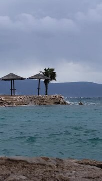 Powerful waves crashing the coast of Njivice, Croatia one day after Storm Ciar&aacute;n smashed into Krk Island. Beautiful rain curtain above the disquiet sea surface. Cinematic water splashes.