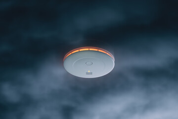 Close-up View of a Modern Illuminated Smoke Detector on a Ceiling