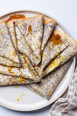 Crepes with poppy seeds, maple syrup and zest.