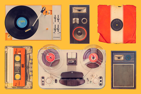 Collection of a vintage turntable, speakers, record, compact cassette and tape recorder on an orange background