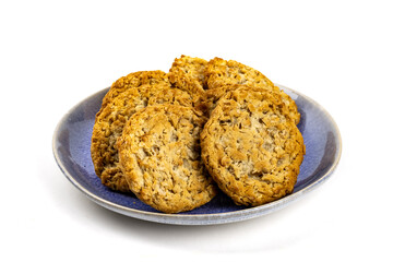 A blue plate filled with tasty oatmeal cookies isolated on white