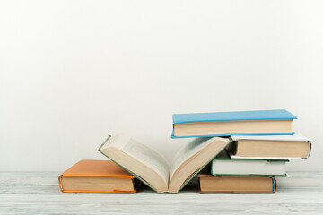 Open book, hardback colorful books on wooden table. Back to school. Copy space for text. Education business concept.