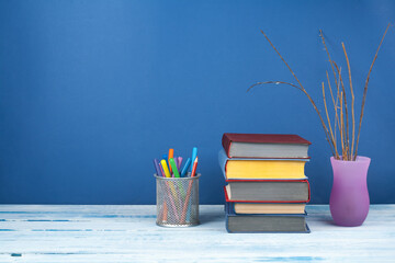 Book stacking. Open book, hardback books on wooden table and blue background. Back to school. Copy...