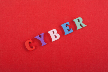 CYBER word on red background composed from colorful abc alphabet block wooden letters, copy space...