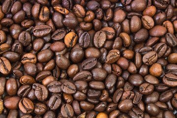 Top view background of aromatic brown coffee beans scattered on surface,